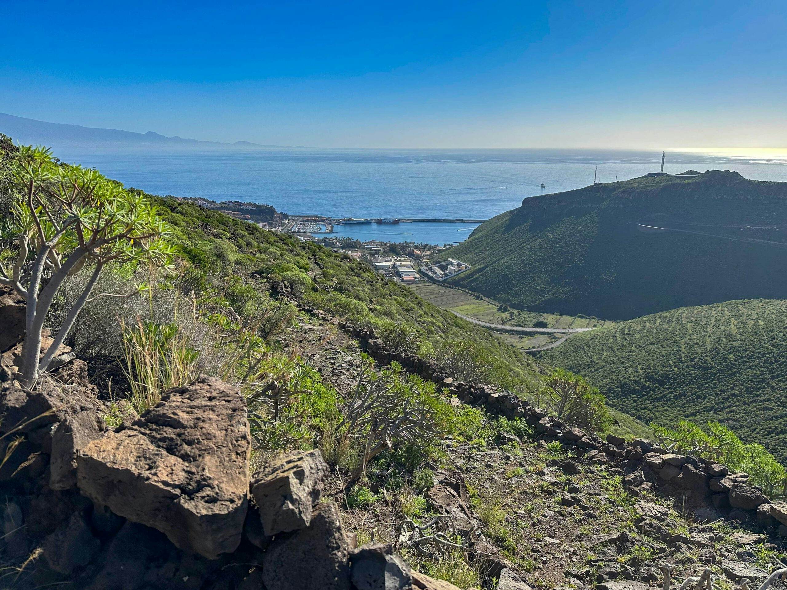 Wandern auf dem Camino mit Blick aus der Höhe auf San Sebastian mit Hafen und Teneriffa